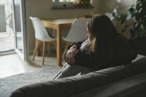 Caucasian sad woman sitting at the sofa with depression