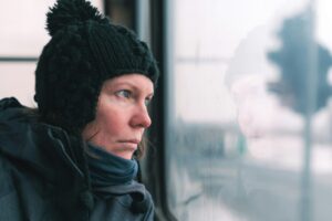 Sad woman on the bus looking through window