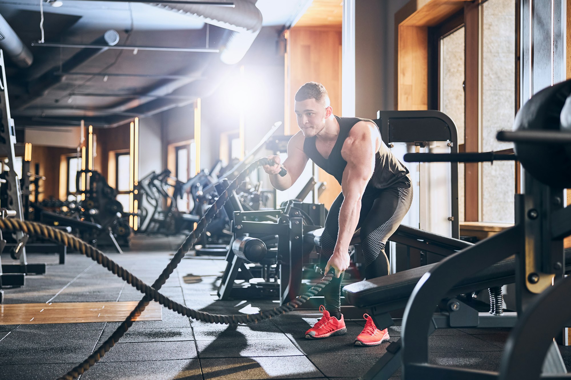 Athletic young man doing HIIT workout in gym