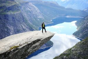 Man standing on the edge of Trolltunga cliff in Norway