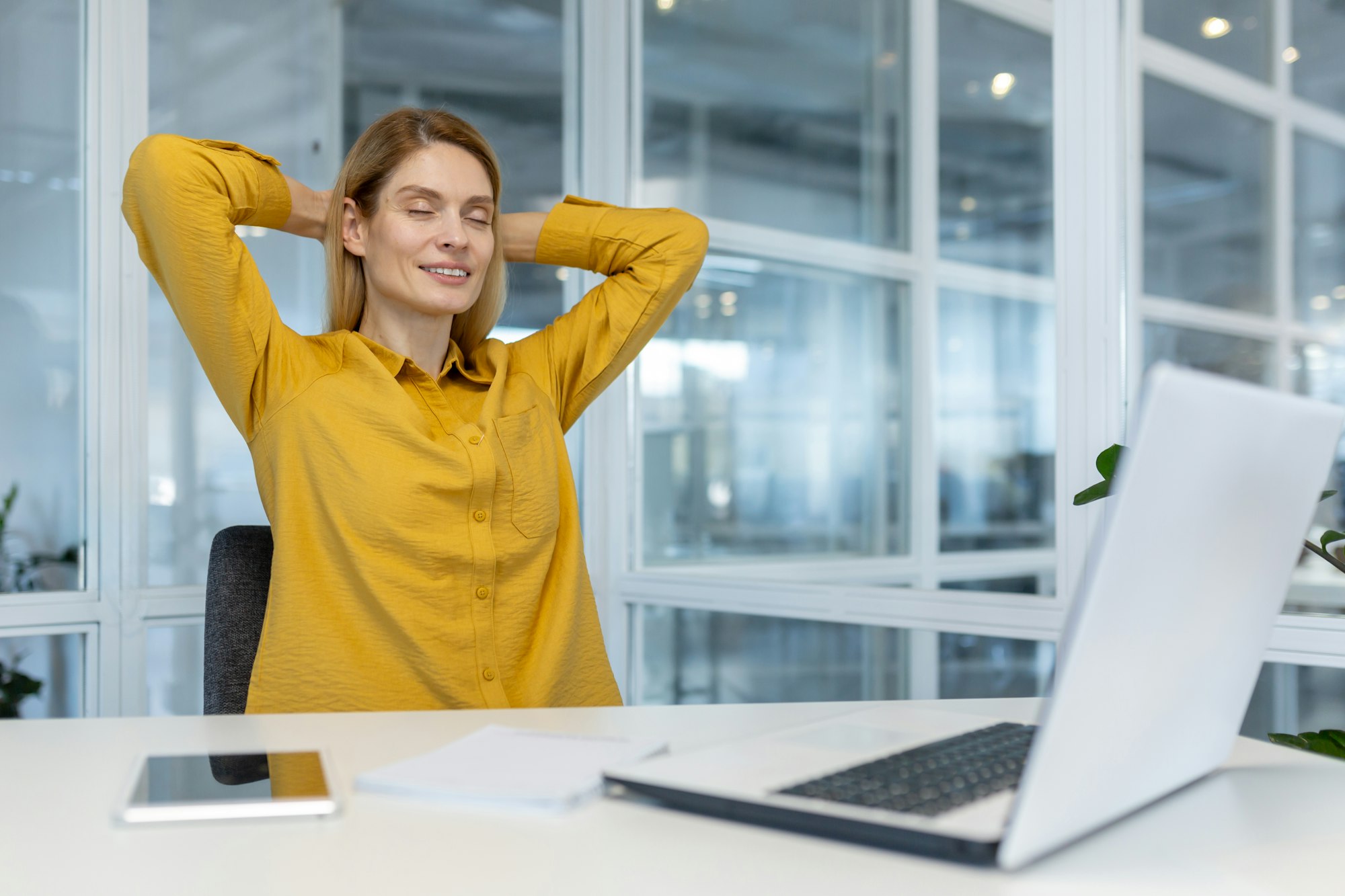 Relaxed professional woman taking a break at her office desk