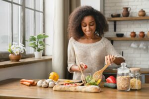 Vegan vegetarian food meal concept. Dieting and healthy eating habits. Girl cooking vegetable salad