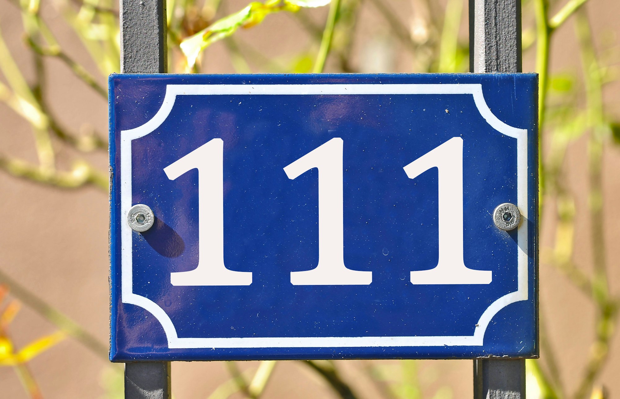 Blue house number plaque, showing the number hundred and eleven (111)