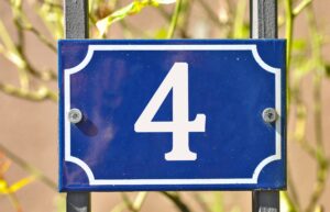 Closeup shot of a blue sign with the number 4 on the blurry background