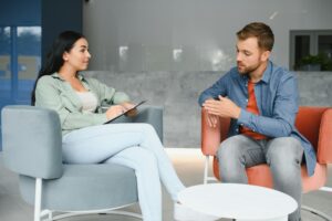 Psychologist talking with patient on therapy session.