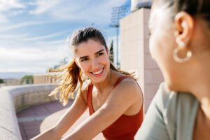 Sportive woman warming up with a friend in a park