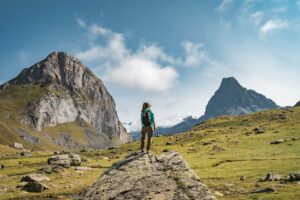 Young Woman With A Backpack on The Top Of a rock in a Beautiful wild Landscape. Discovery Travel