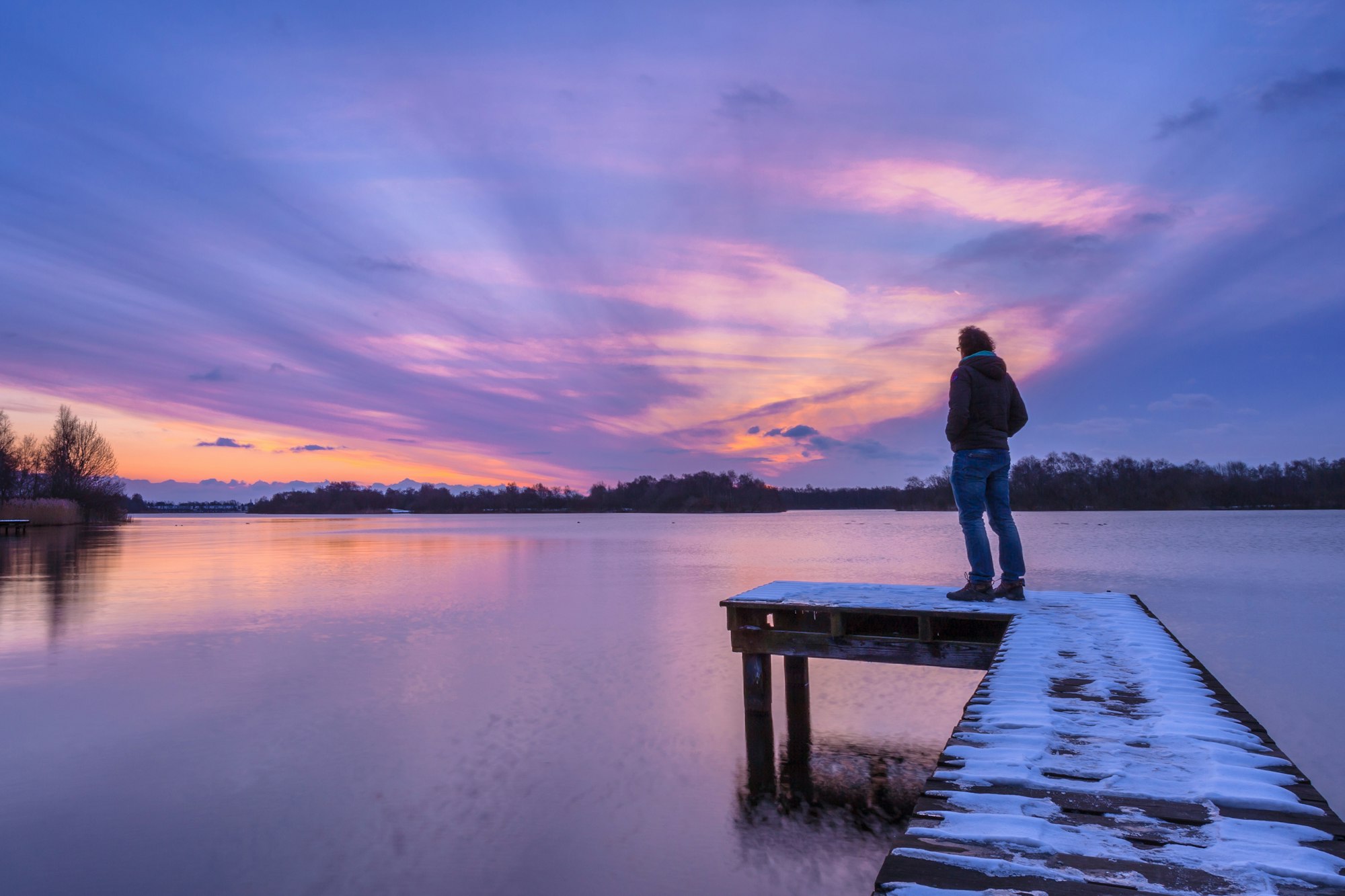 Man Looking at the Sunset From a Pier